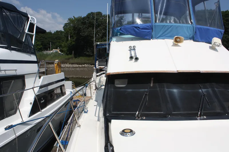 Slide: The Image of 1986 Birchwood 42 Empress yacht docked, featuring blue canopy and sleek design. - 12