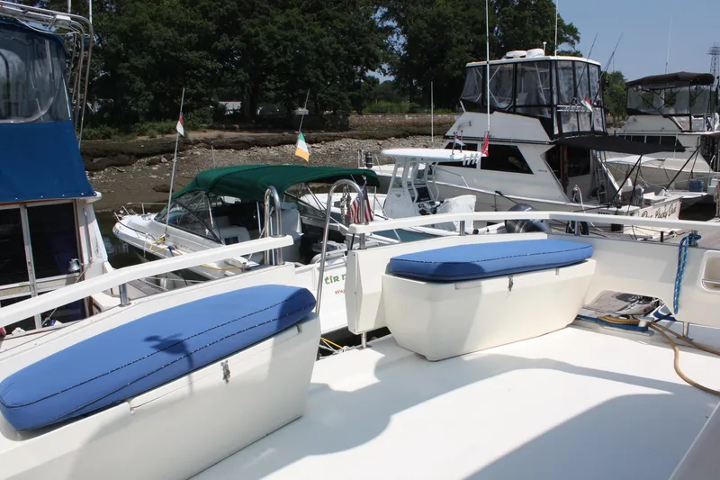 Slide: The Image of 1986 Birchwood 42 Empress yacht with blue cushions docked among other boats. - 13