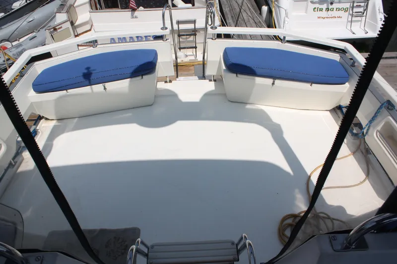 Slide: The Image of 1986 Birchwood 42 Empress yacht deck with blue cushioned seating and dock view. - 14