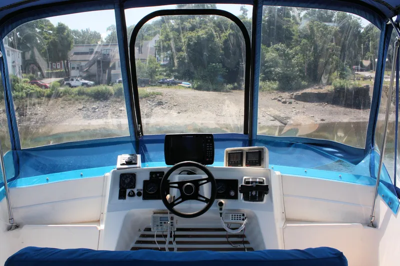 Slide: The Image of 1986 Birchwood 42 Empress boat cockpit with steering wheel and navigation equipment. - 18