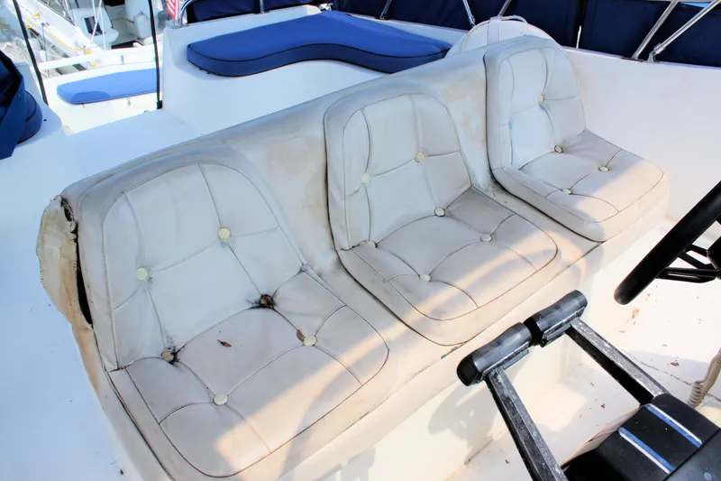 Slide: The Image of 1986 Birchwood 42 Empress boat interior with white cushioned seating and steering wheel. - 20