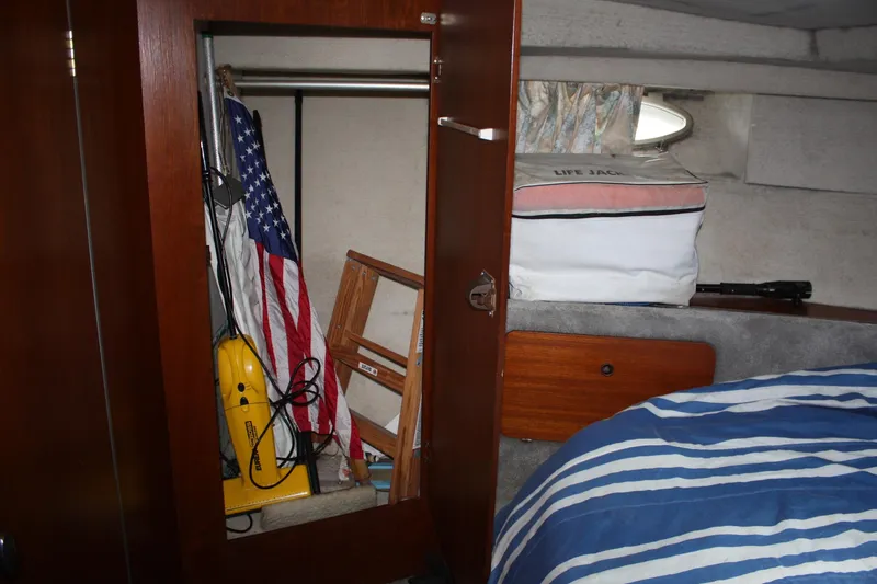 Slide: The Image of Interior of 1986 Birchwood 42 Empress boat with American flag and striped bedding. - 24