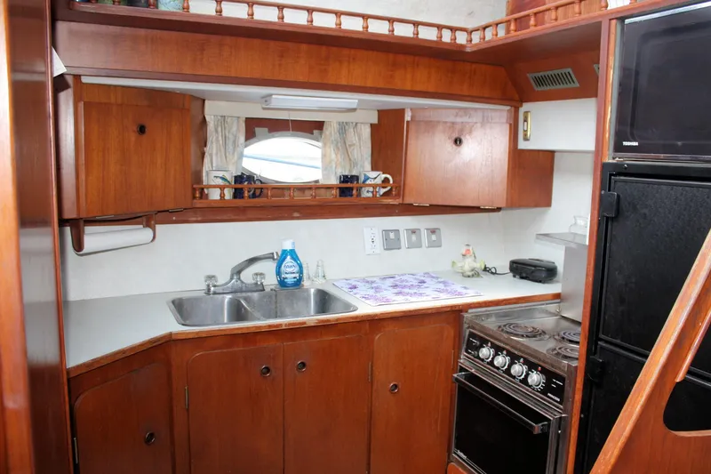 Slide: The Image of 1986 Birchwood 42 Empress yacht kitchen with wooden cabinets and modern appliances. - 30