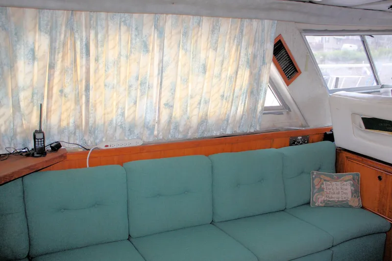 Slide: The Image of Interior of 1986 Birchwood 42 Empress yacht with teal sofa and floral curtains. - 37