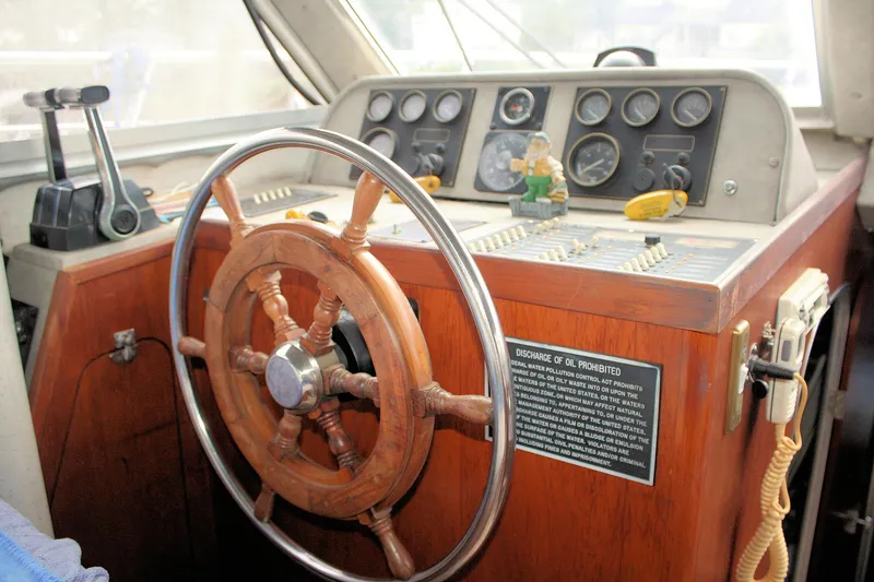 Slide: The Image of Control panel of a 1986 Birchwood 42 Empress boat with wooden steering wheel. - 38