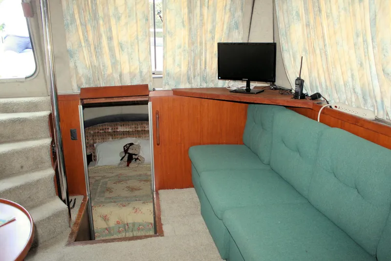 Slide: The Image of Interior of 1986 Birchwood 42 Empress yacht with teal sofa, TV, and cabin entrance. - 40