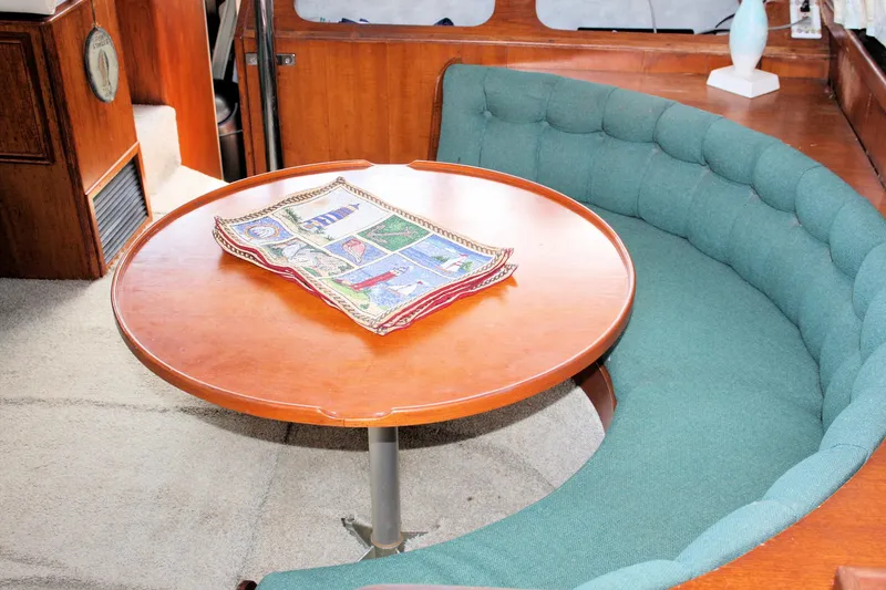 Slide: The Image of Interior of 1986 Birchwood 42 Empress yacht with round table and curved seating. - 43