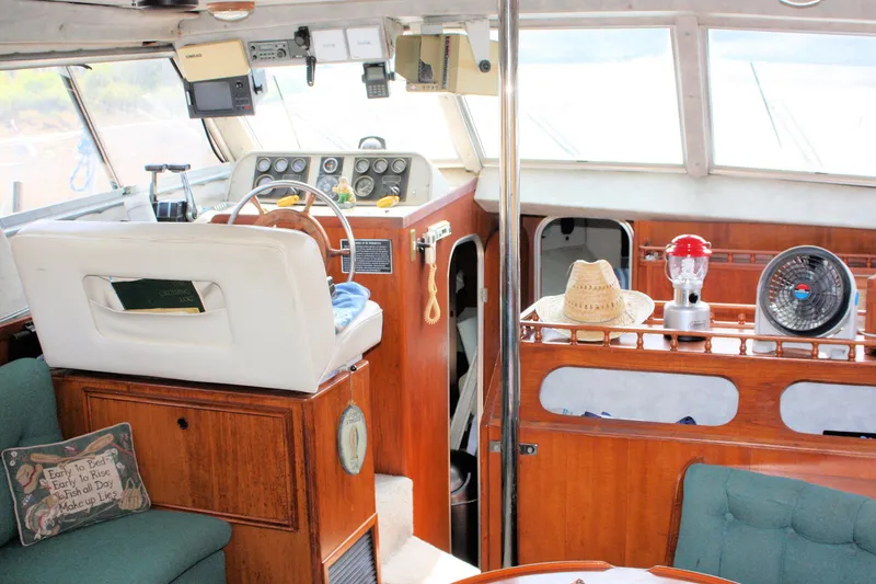 Slide: The Image of 1986 Birchwood 42 Empress yacht interior with wooden finish, steering wheel, and nautical decor. - 45