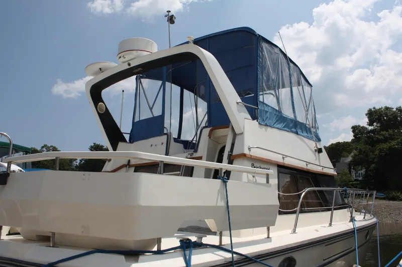 Slide: The Image of 1986 Birchwood 42 Empress yacht docked under a partly cloudy sky. - 5