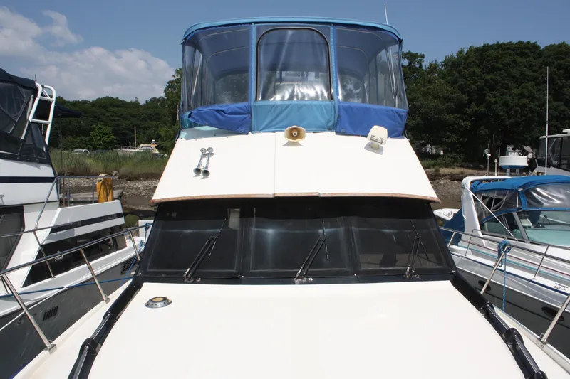 Slide: The Image of 1986 Birchwood 42 Empress yacht docked, featuring blue canopy and sleek design. - 9