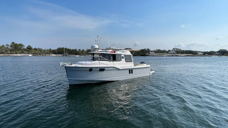 The Image of 2024 Ranger Tugs R-25 boat on calm water under clear blue sky. - 0