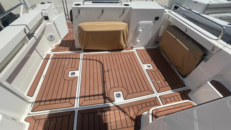 Slide: The Image of 2024 Ranger Tugs R-25 boat deck with wood finish and covered seating. - 12