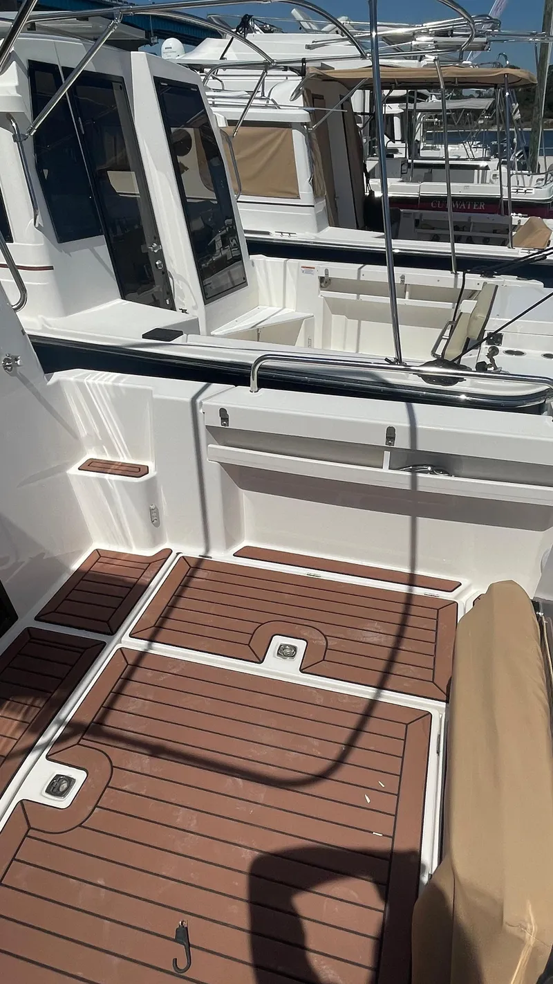 Slide: The Image of 2024 Ranger Tugs R-25 boat deck with wood finish and seating area. - 14