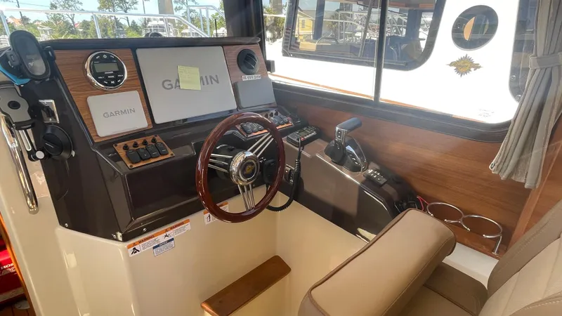 Slide: The Image of 2024 Ranger Tugs R-25 helm with Garmin navigation system and wooden accents. - 18