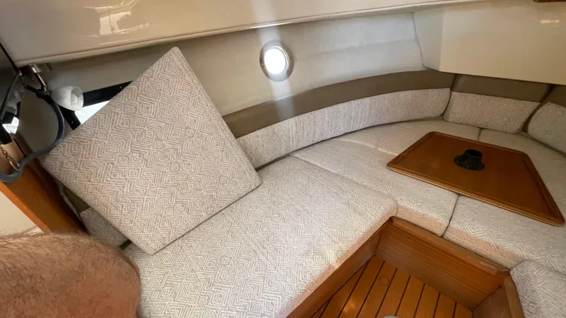 Slide: The Image of 2024 Ranger Tugs R-25 interior with cushioned seating and wooden table. - 27