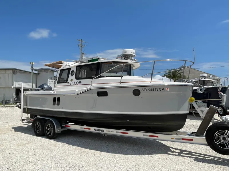 Slide: The Image of 2024 Ranger Tugs R-25 boat on trailer under clear blue sky. - 6