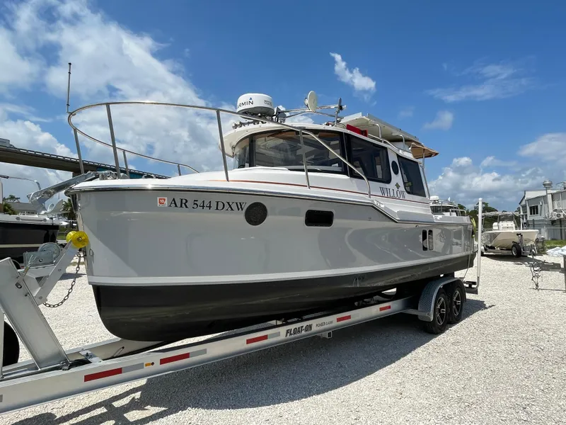 Slide: The Image of 2024 Ranger Tugs R-25 boat on trailer under clear blue sky. - 8