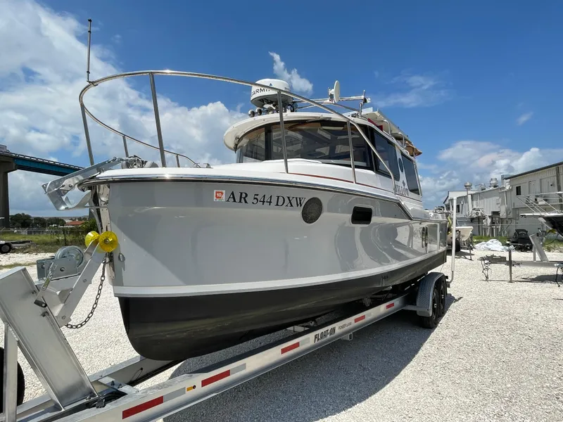 Slide: The Image of 2024 Ranger Tugs R-25 boat on trailer under clear blue sky. - 9