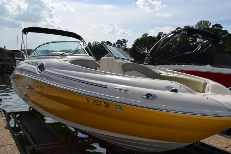 The Image of 2005 Sea Ray 240 Sundeck boat with yellow hull docked at marina. - 0