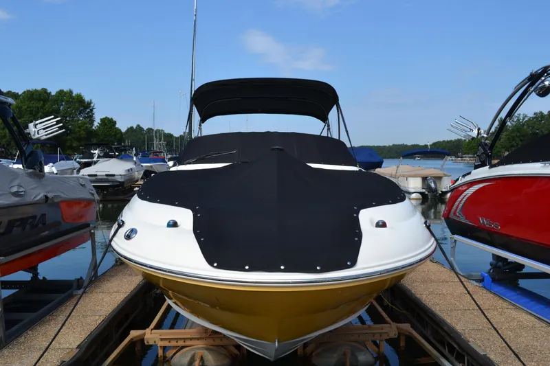 Slide: The Image of 2005 Sea Ray 240 Sundeck boat docked with black cover and yellow hull. - 1