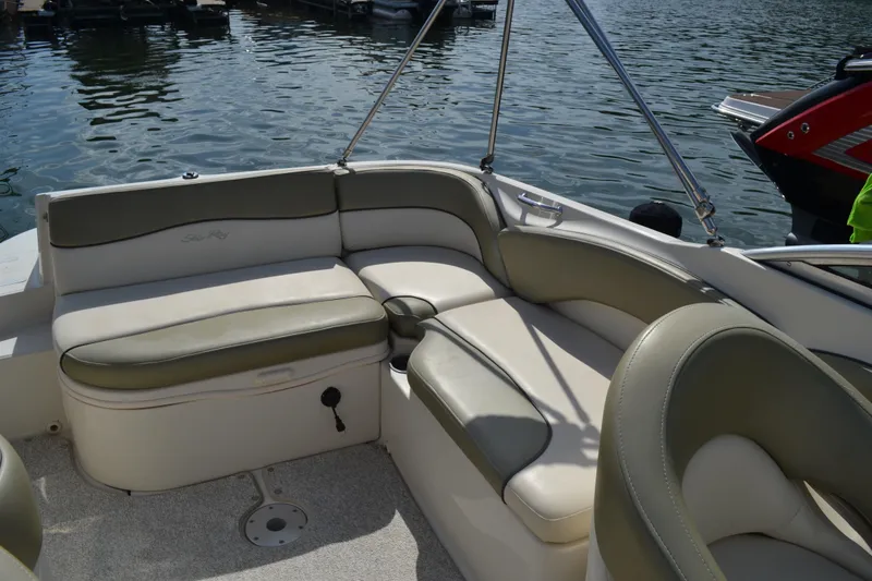 Slide: The Image of 2005 Sea Ray 240 Sundeck boat interior with cushioned seating by the water. - 10