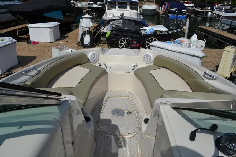 Slide: The Image of 2005 Sea Ray 240 Sundeck boat interior with spacious seating at a marina. - 14