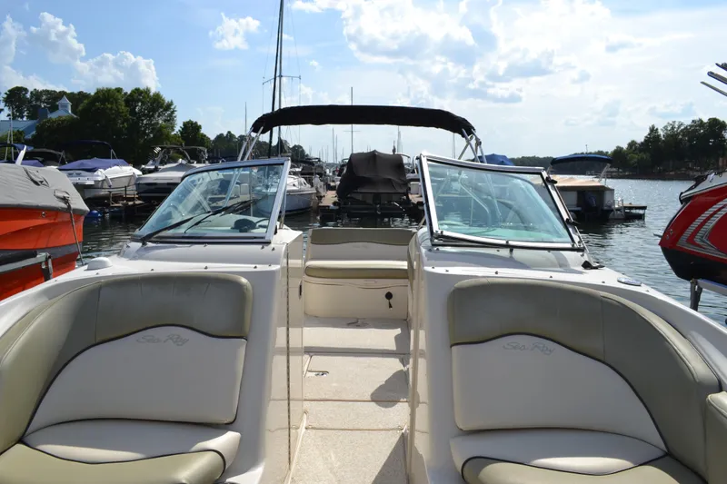 Slide: The Image of 2005 Sea Ray 240 Sundeck boat interior with open bow seating at a marina. - 15