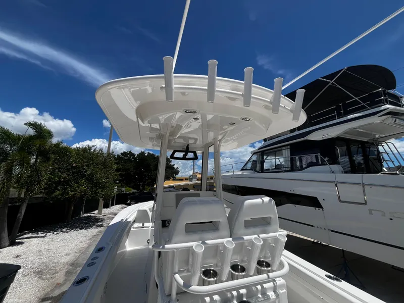 Slide: The Image of 2025 Regulator 23 boat with dual seats and rod holders under a clear blue sky. - 11