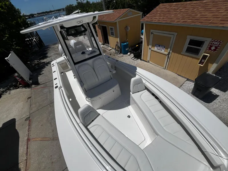 Slide: The Image of 2025 Regulator 23 boat docked near yellow sheds by the water. - 27