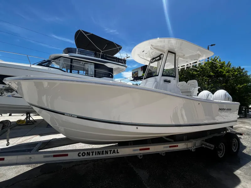 Slide: The Image of 2025 Regulator 23 boat on Continental trailer under clear blue sky. - 7