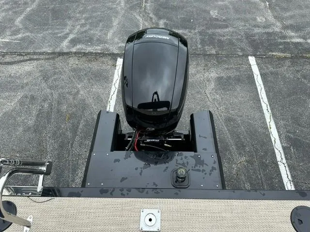 Slide: The Image of 2024 Regency 230 DL3 boat with Mercury outboard motor in parking lot. - 10