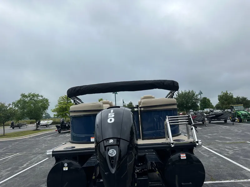 Slide: The Image of 2024 Regency 230 DL3 pontoon boat with 150 HP engine in parking lot. - 3