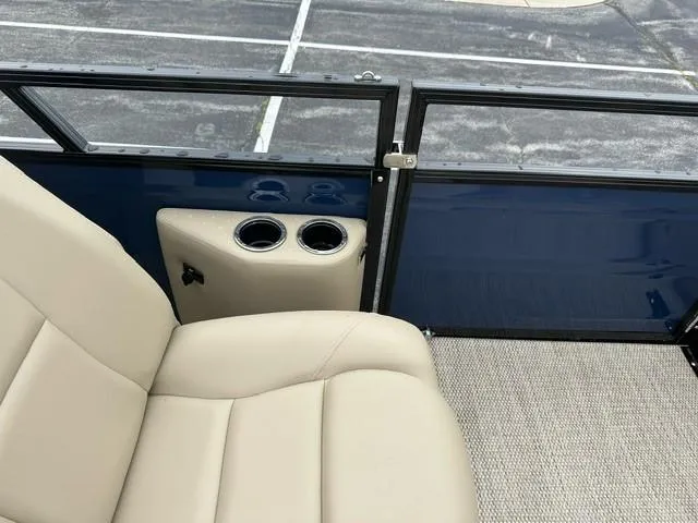 Slide: The Image of 2024 Regency 230 DL3 boat interior with beige seating and cup holders. - 9