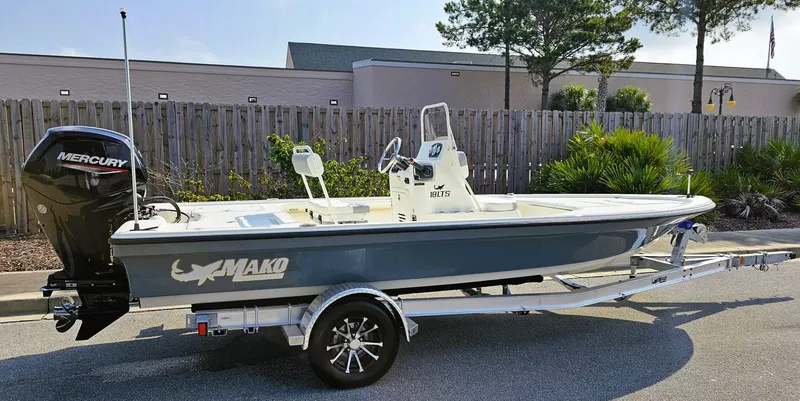 Slide: The Image of 2024 Mako 18 LTS boat with Mercury engine on trailer, parked outdoors. - 6