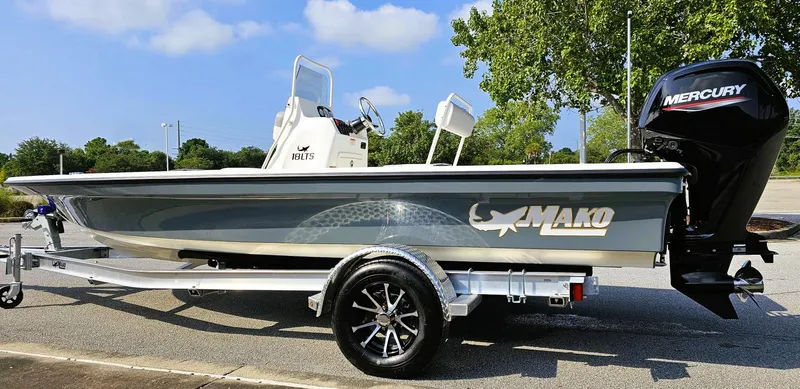 Slide: The Image of 2024 Mako 18 LTS boat on trailer with Mercury engine, parked outdoors. - 8