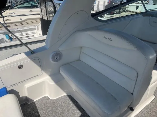 Slide: The Image of 2005 Sea Ray 280 Sundancer boat interior with white seating and carpeted floor. - 10