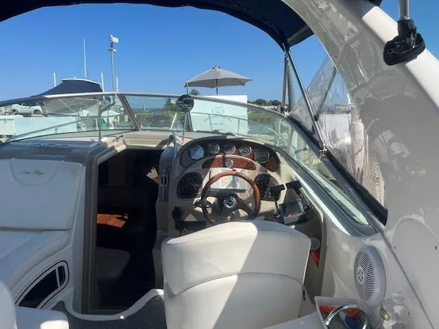 Slide: The Image of 2005 Sea Ray 280 Sundancer boat cockpit with steering wheel and dashboard. - 13