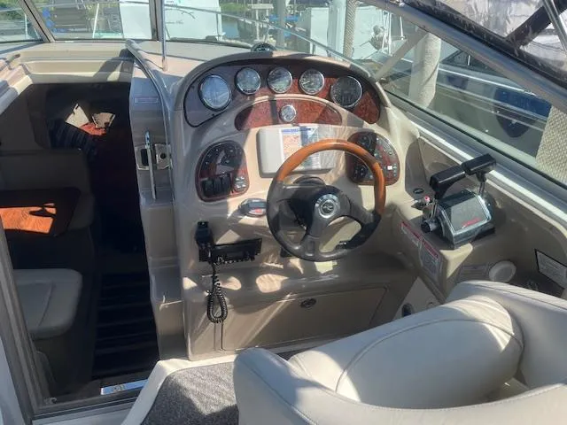 Slide: The Image of 2005 Sea Ray 280 Sundancer boat cockpit with steering wheel and control panel. - 15