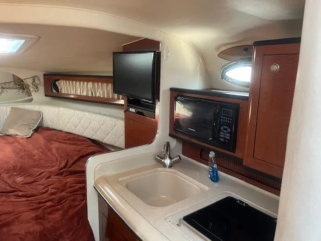 Slide: The Image of Interior of 2005 Sea Ray 280 Sundancer with bed, TV, sink, and microwave. - 21