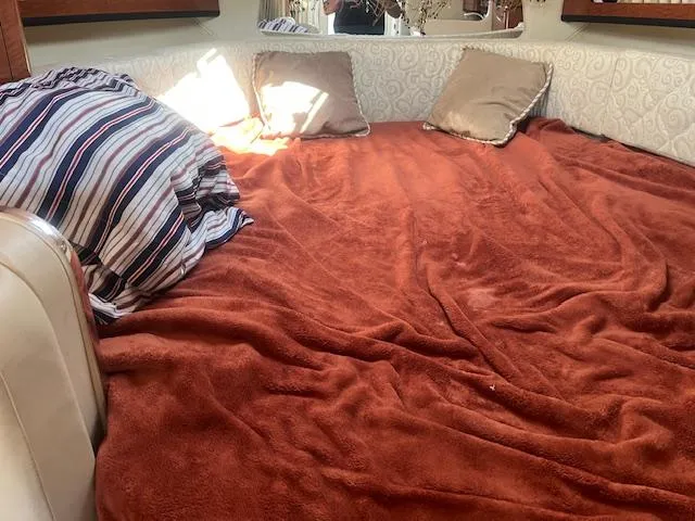 Slide: The Image of Cozy cabin bed in a 2005 Sea Ray 280 Sundancer with pillows and a striped blanket. - 22