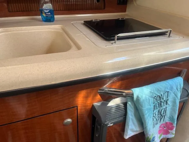Slide: The Image of 2005 Sea Ray 280 Sundancer kitchen area with sink and stove. - 24
