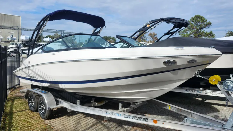 The Image of 2025 Regal 21 OBX boat on trailer, sleek design, outdoor display. - 0