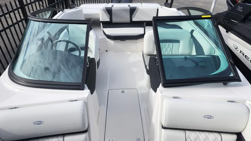 Slide: The Image of 2025 Regal 21 OBX boat interior with dual windshields and white seating. - 11