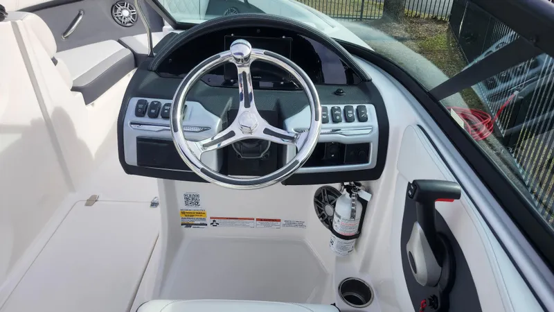 Slide: The Image of 2025 Regal 21 OBX boat storage compartment with open lid and cup holder. - 30