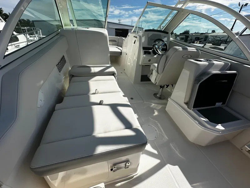 Slide: The Image of 2025 Sailfish 245 DC boat interior with white seating and modern dashboard. - 12