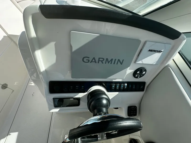Slide: The Image of 2025 Sailfish 245 DC boat dashboard with Garmin navigation system and Mercury controls. - 17