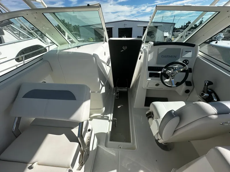 Slide: The Image of 2025 Sailfish 245 DC boat interior with Garmin navigation system and seating. - 18