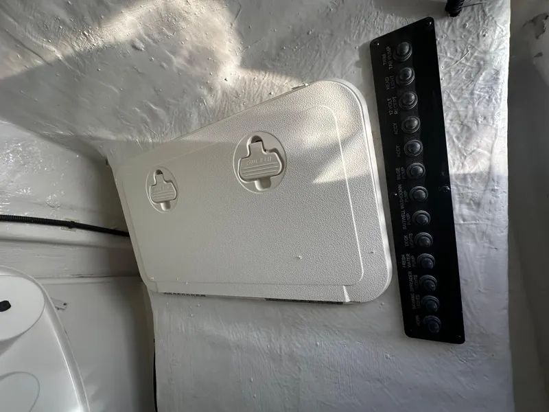 Slide: The Image of Control panel and storage compartment on a 2025 Sailfish 245 DC boat. - 20