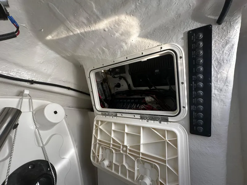 Slide: The Image of Electrical panel and access hatch inside a 2025 Sailfish 245 DC boat. - 21