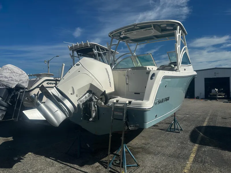 Slide: The Image of 2025 Sailfish 245 DC boat on stands, rear view with outboard motor. - 5